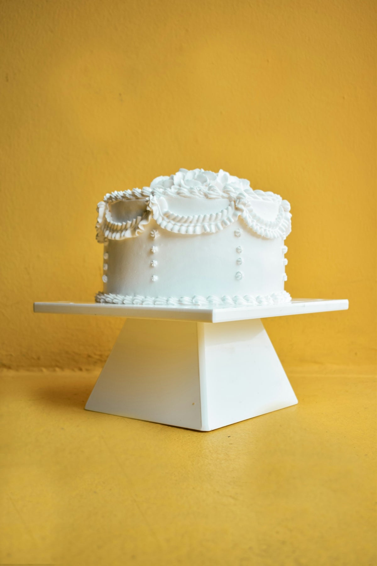 a white cake on a white pedestal