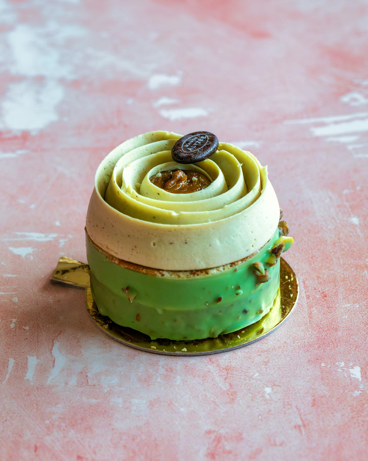 a green cake with a cookie on top of it