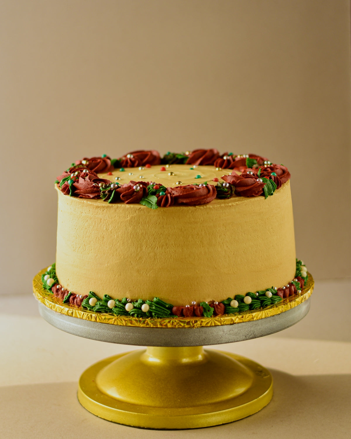 a decorated cake on a gold pedestal on a table