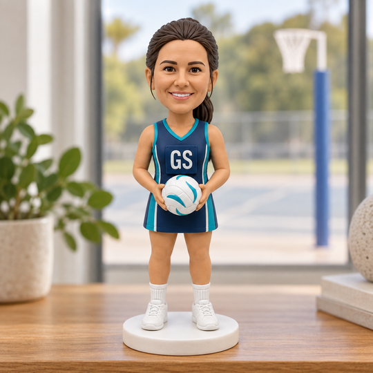 Custom netball player bobblehead displayed near netball court