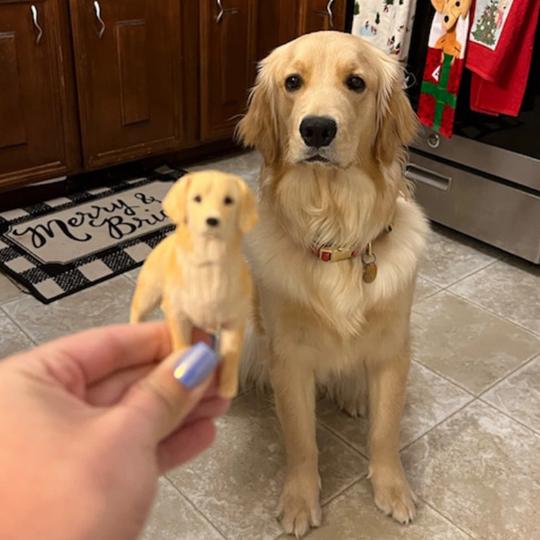 Small handmade golden dog figurine held beside the golden dog used as its reference
